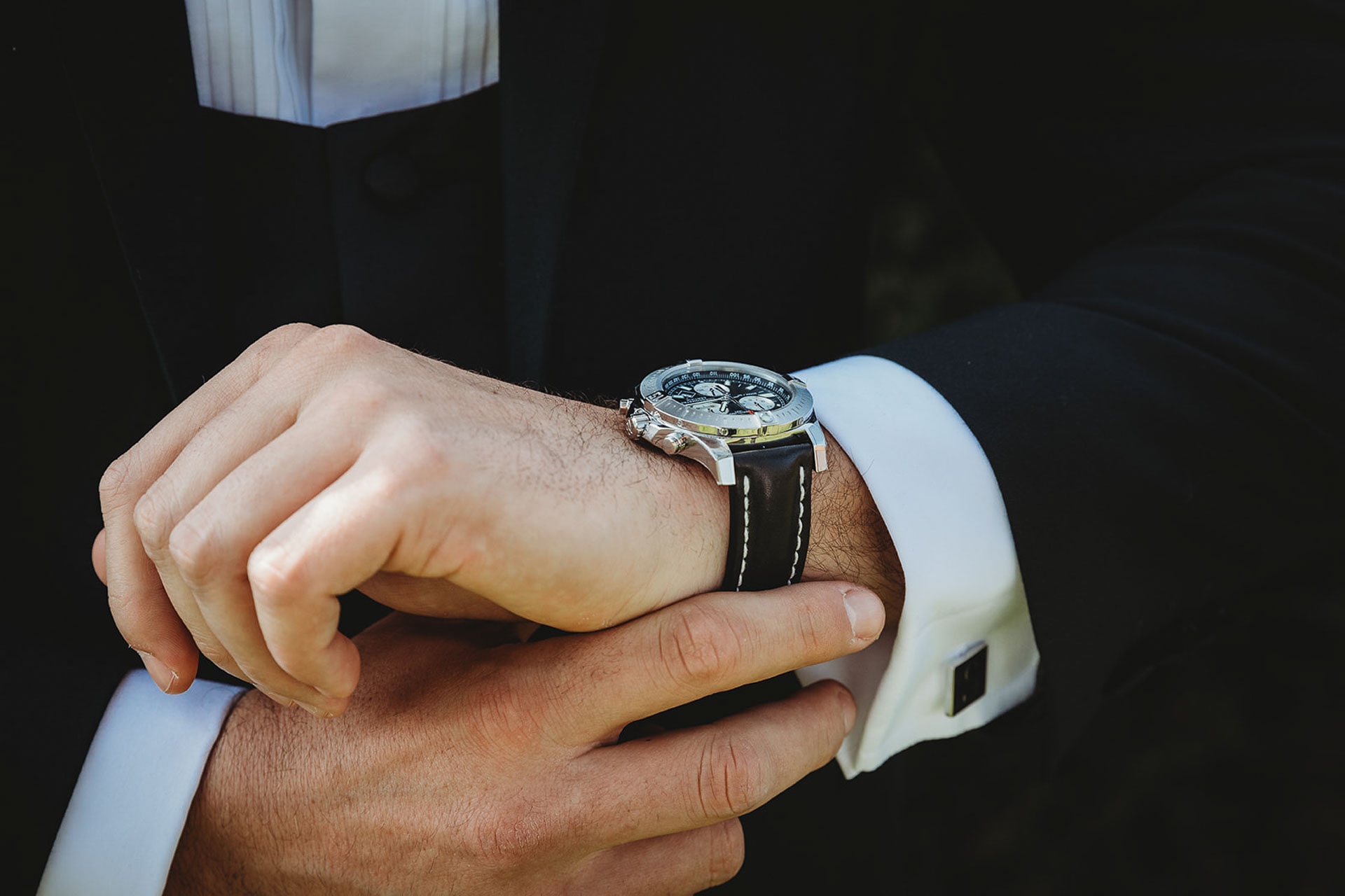 A groom checks his watch just before his wedding at Bilsington Priory