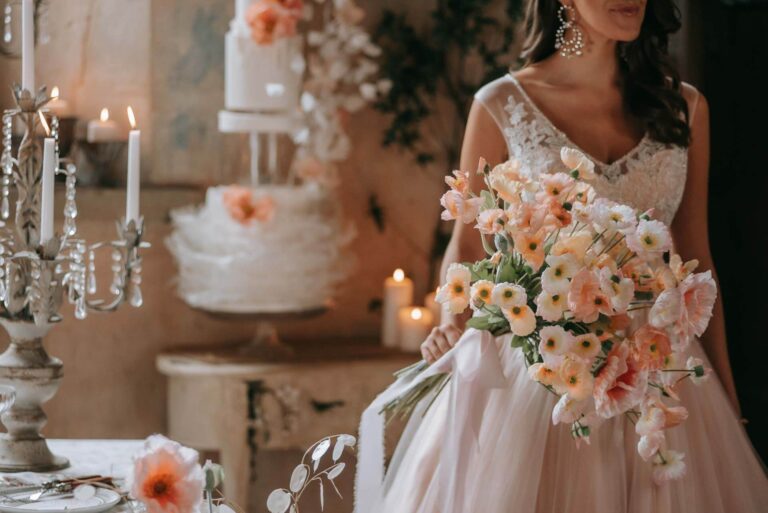 A bride with her bouquet and wedding cake in the Great Hall of Bilsington Priory