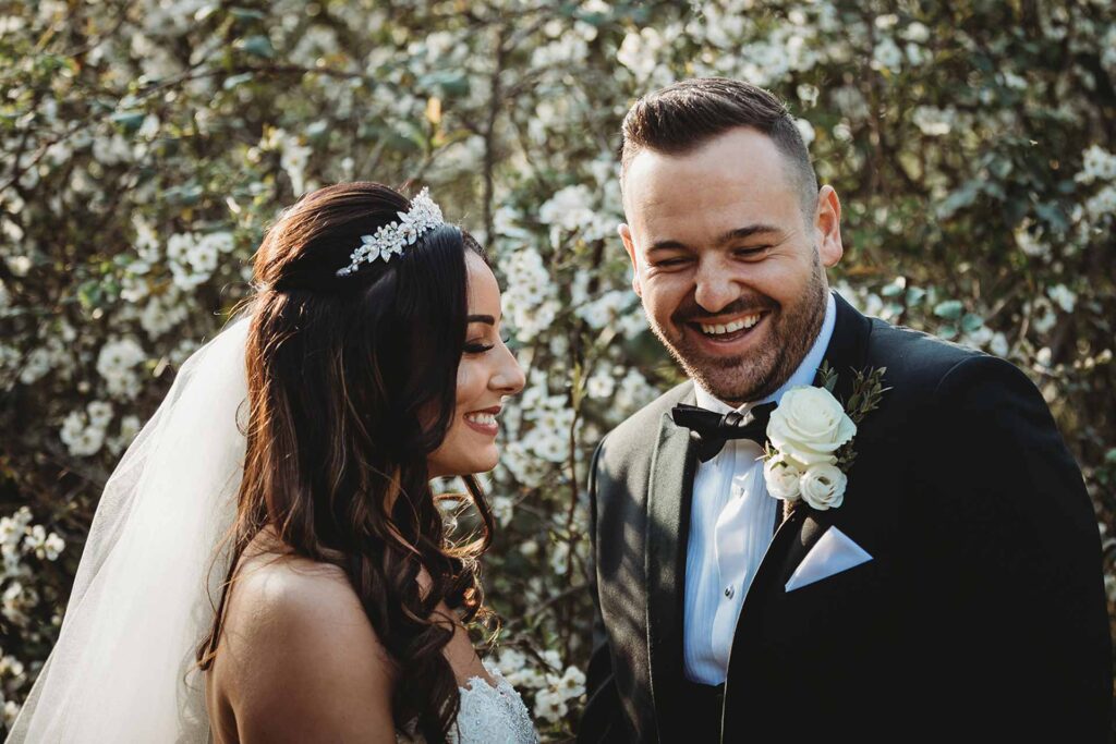 The couple have a laugh after their wedding during their couple shots in the Enchanted Garden at Bilsington Priory 