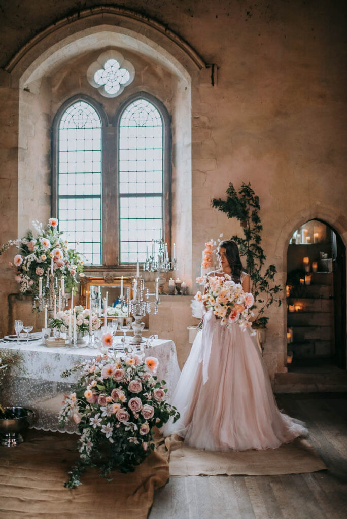 A bride with her bouquet in the Great Hall of Bilsington Priory Kent