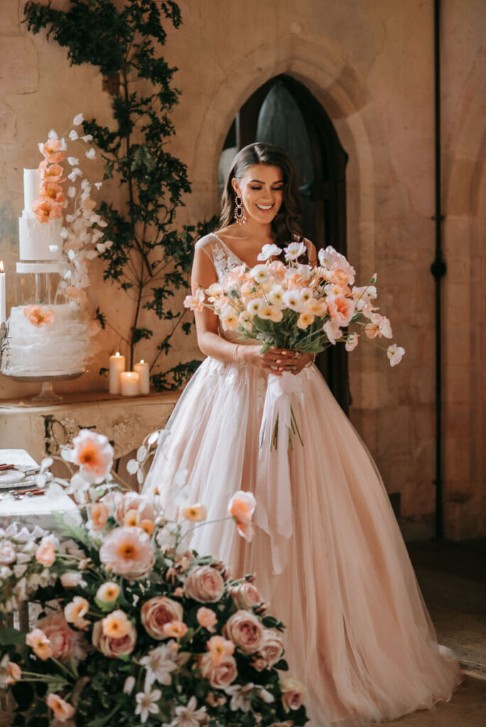 A bride with her bouquet in the Great Hall of Bilsington Priory Kent