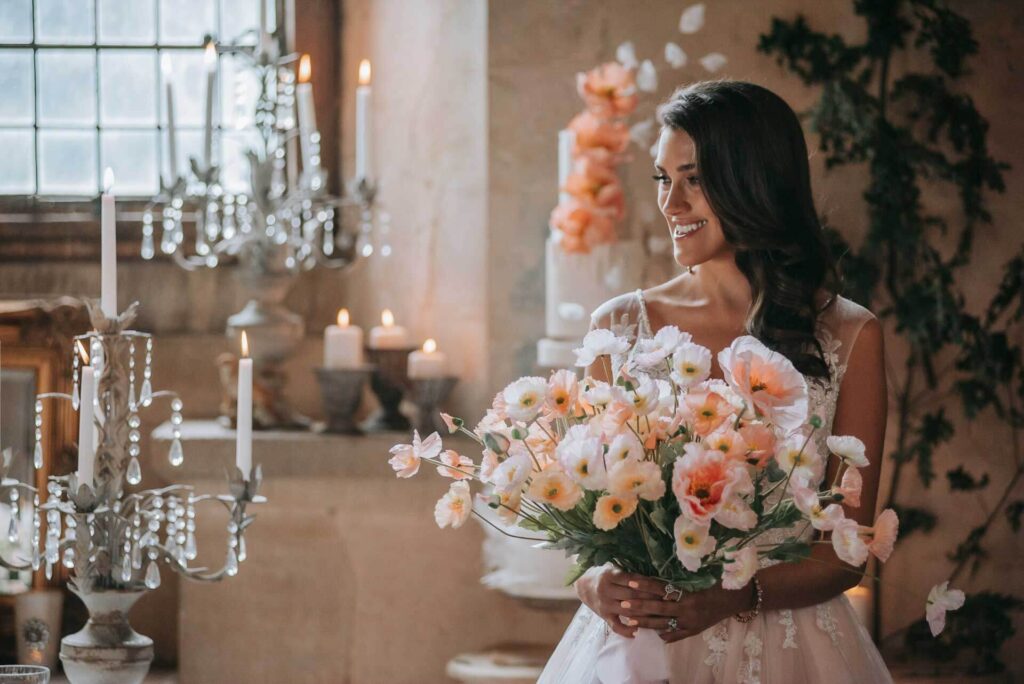 A bride with her bouquet in the Great Hall of Bilsington Priory Kent