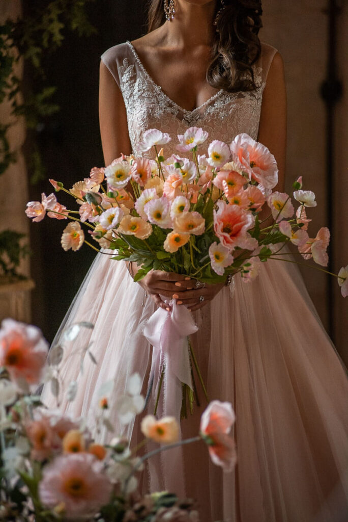 A bride with her bouquet in the Great Hall of Bilsington Priory Kent