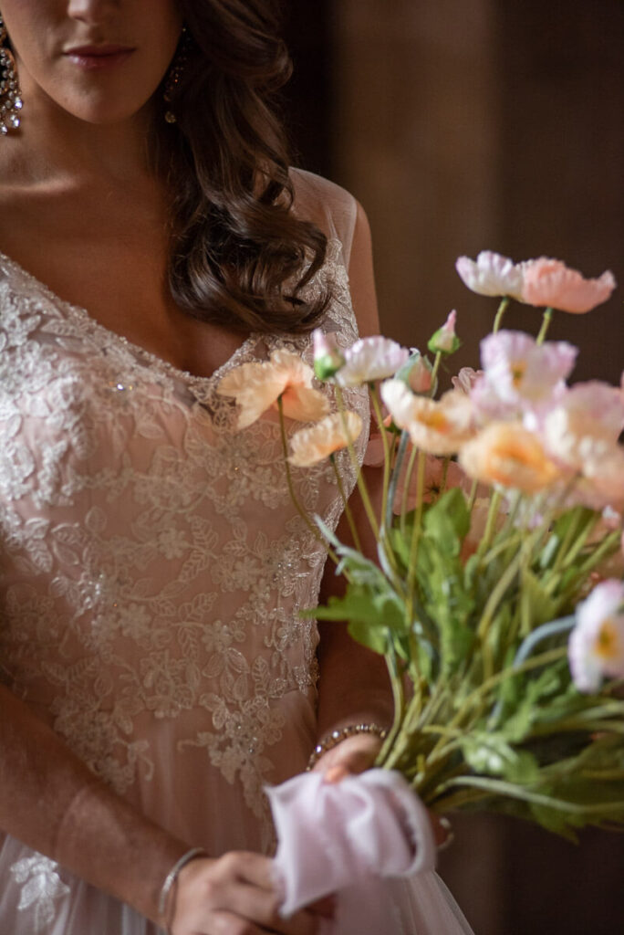 A bride with her bouquet in the Great Hall of Bilsington Priory Kent